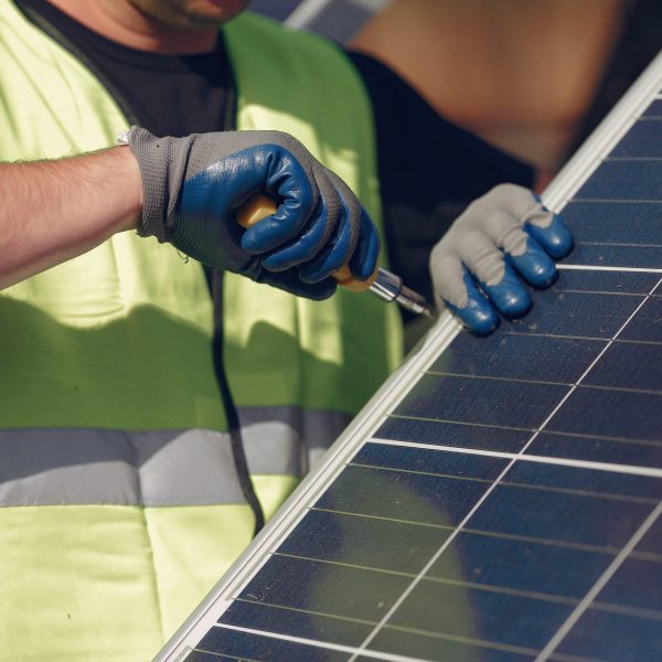 Engineer in a white helmet. Man near solar panel.